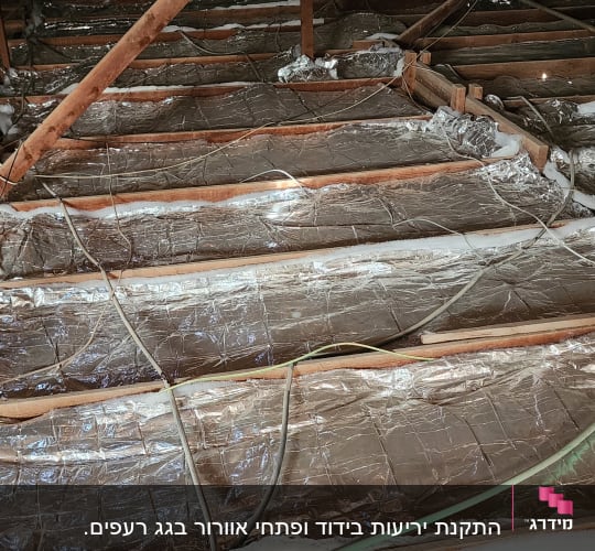 קורות עץ וגג עם בידוד מתכתי בעליית גג